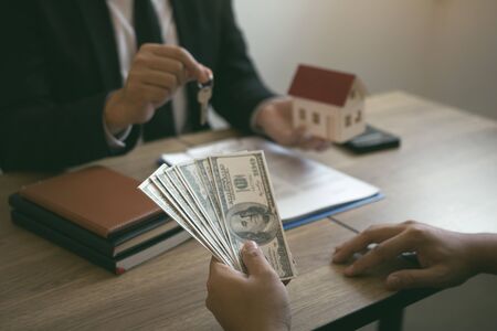 Businessman handed the house model and new homeowner giving money to real estate trading.