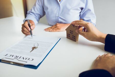 Home agents are sending pens to customers signing a contract to buy a new home.の写真素材