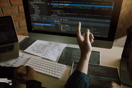 Two software developers are analyzing together about the code written into the program on the computer.の写真素材