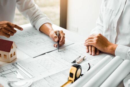 The partnership engineering man or co-workers working on a project and discussing together with looking at blueprint paperwork.の写真素材