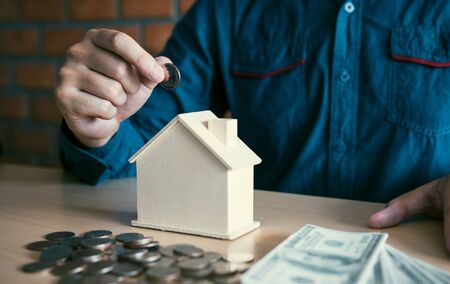 Men are putting coins together with the idea of collecting money to buy a new house.