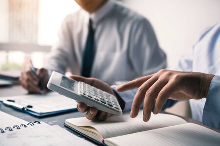 Group of businessmen discussion analysis sharing calculations about the company budget or cost working together and financial planning together on desk at the office room.の写真素材