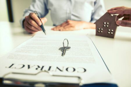 Home agents are sending pens to customers signing a contract to buy a new home.の写真素材