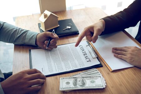 Insurance brokers are pointing to insurance contract signing and are explaining to customers at the office.の写真素材