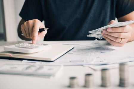 Man use calculators and documents that calculate expenses in the home office.の写真素材