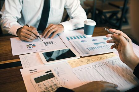 Manager calculates about the company finances by pressing on the calculator on the table with the...