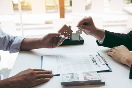 Insurance brokers are pointing to insurance contract signing and are explaining to customers at the...