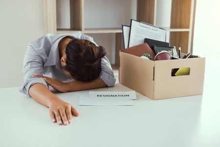 Woman employee feeling sad at his desk when he received the contract envelope for resigning from the company.の写真素材