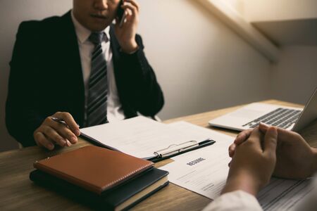 Serious asian businessman important conversation with male employee are reviewing resume documents.の写真素材