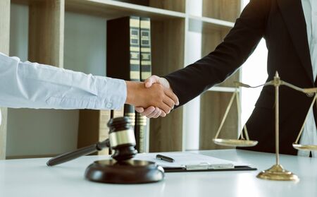 Lawyer is currently shaking hands with the client about the success in resolving the case.