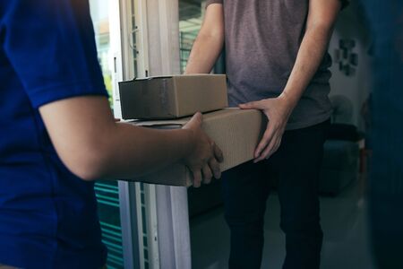 Close up of hands cargo staff are delivering cardboard boxes with parcels inside to the recipient's hand.の写真素材