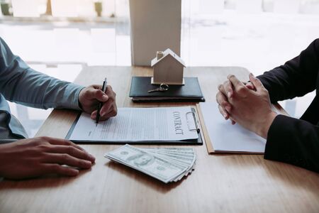 New home buyers are signing a home purchase contract at the agent's desk.の写真素材