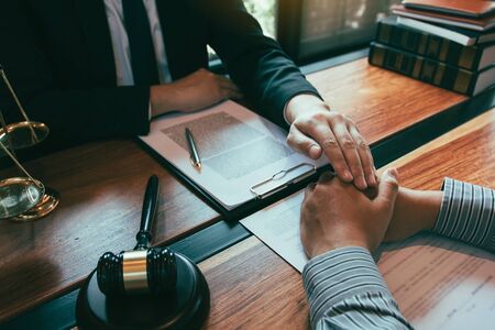 Lawyer and the court are using their hands to console the client who is aware that they will not win the case.の写真素材