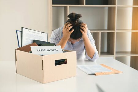 Female staff was worried about the resignation of the company while holding hands to the head.の写真素材