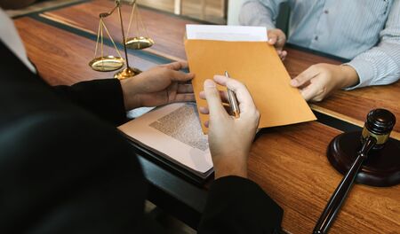 Client is submitting information on the paper of the prosecution document to the lawyer.の写真素材