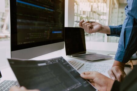 Two partnerships developing programming and coding technologies working on laptop and analyzing together.の写真素材