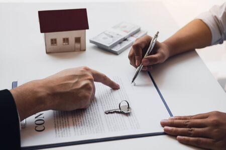 New home buyers are signing a home purchase contract at the agent's desk.