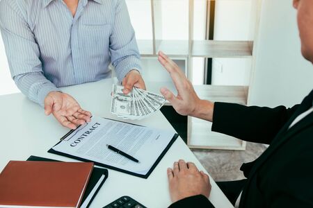 Businessperson refusing bribe given money by partner with anti bribery corruption concept.