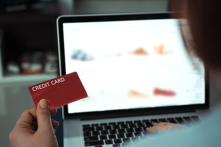 Online shopping concept with woman hand using laptop and looking credit card for purchase order...
