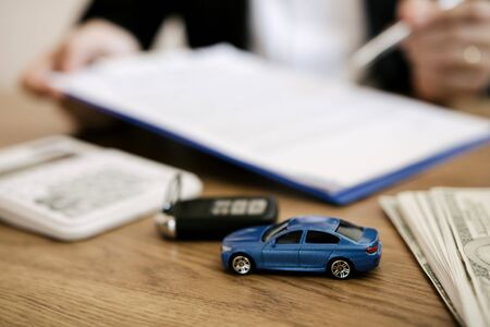 Agent car salesman is explaining about the new car purchase contract and agreement to the car buyer.の写真素材