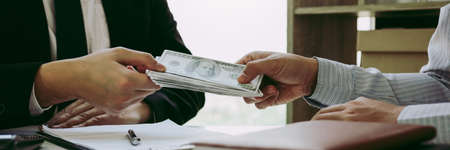 Entrepreneurs are receiving money that is a bribe of their partners with both of whom are corrupt in the company room.の写真素材