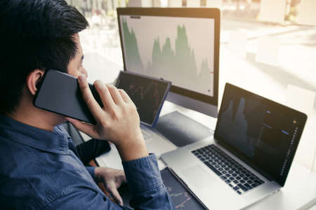 Two asian agent man working and analysis together in office  market financial charts and graphs and...