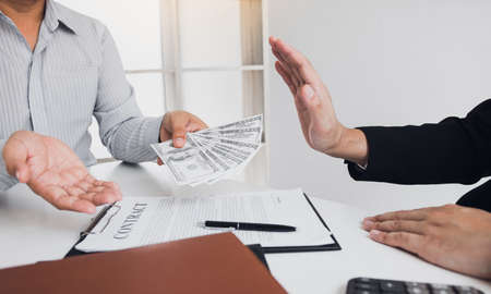 Businessperson refusing bribe given money by partner with anti bribery corruption concept.の写真素材