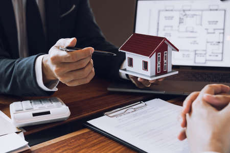 New home buyers are signing a home purchase contract at the agent's desk.