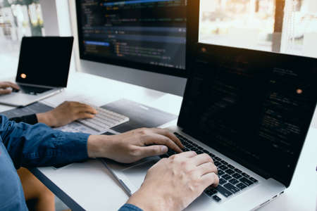 Two software developers are analyzing together about the code written into the program on the...