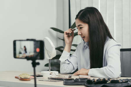 Young Asian beauty blogger is showcasing cosmetic products as well as tutorials on how to apply and...