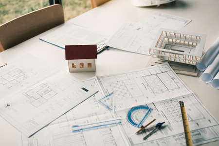 Close up model house on table and blueprint in the office room.