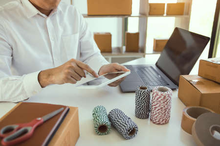 Teen business owners are using the tablet to browse the products that customers order.