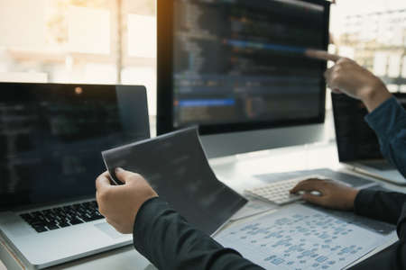Two software developers are analyzing together about the code written into the program on the...