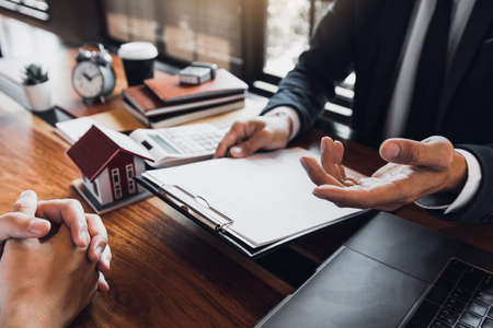 Insurance brokers are pointing to insurance contract signing and are explaining to customers at the...
