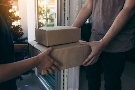 Close up of hands cargo staff are delivering cardboard boxes with parcels inside to the recipient's hand.の写真素材