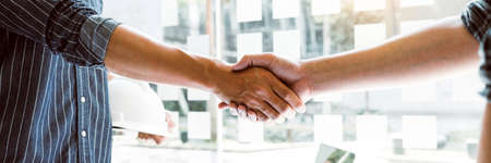 Two engineering man with construction worker greeting a foreman at renovating apartment.の写真素材