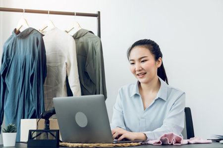 Young asian entrepreneurs chatting with customers at the computer while smiling.の写真素材