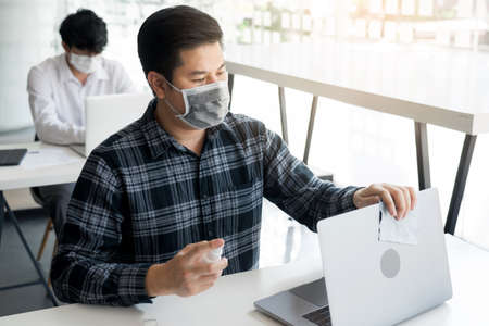 Employees are spraying with alcohol to wipe clean office equipment.