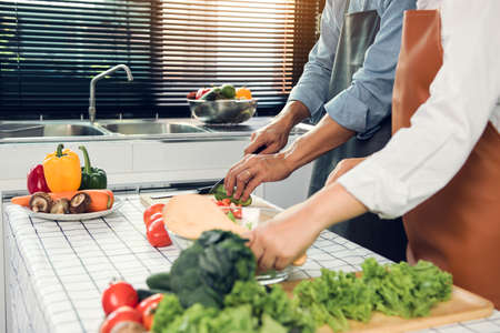 Asian Couple having fun while cooking a meal in kitchen.の写真素材