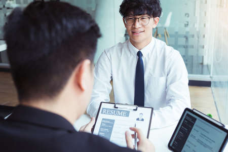 The interview room while the staff is preparing the resume document and presenting to the manager who is talking and analyzing about the work experience.の写真素材