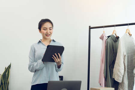Young asian entrepreneurs use a tablet while checking online purchase orders.の写真素材