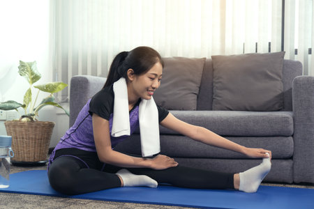 Asian women do stretching exercises after taking yoga classes while at home.の写真素材