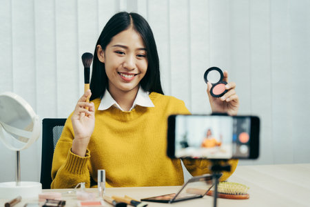 Young Asian beauty blogger is showcasing cosmetic products as well as tutorials on how to apply and record makeup tutorials on social media networks.の写真素材