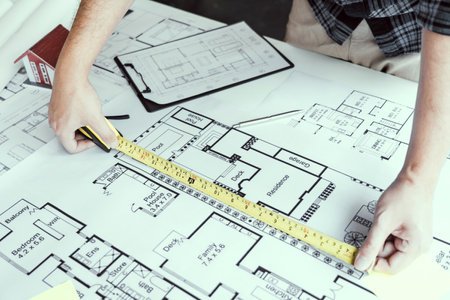 Architects are working on a new project while using a tape measure.