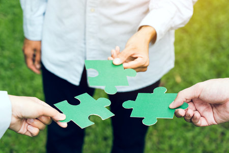 group of business people assembling jigsaw puzzle. The concept of cooperation, teamwork, help and support in business.の写真素材