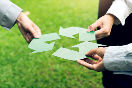 People holding recycle symbol against green spring background. Earth day holiday concept.の写真素材