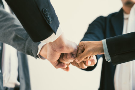 Teamwork, team building, responsibility and equal opportunities. Hand holding together bumping fists...