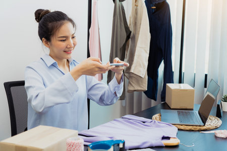 Asian entrepreneurs chatting with customers and taking pictures of their products sent to choose from a collection.の写真素材