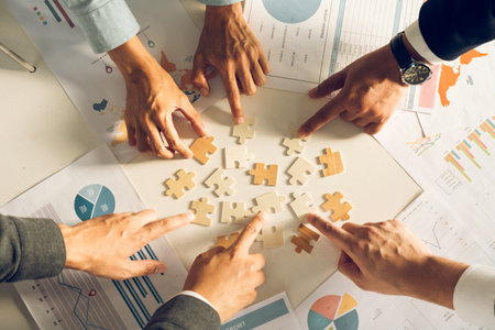 The concept of teamwork and partnership. Businessman's hands putting together puzzle pieces in the...