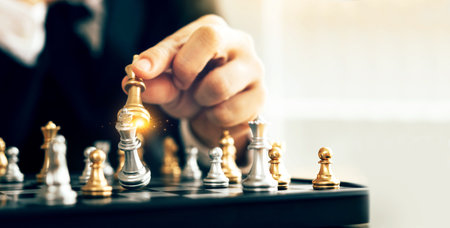 Businessman confident in his strategy, moving the king piece in a chess game towards victory.